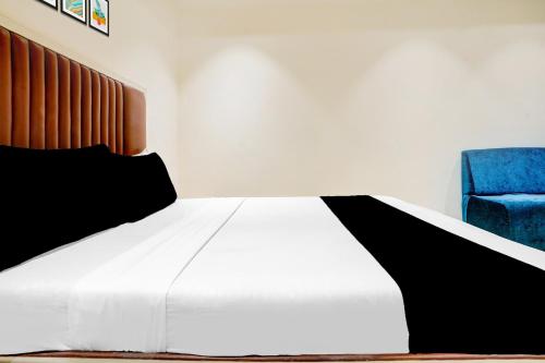 a bedroom with a bed and a blue chair at Super Collection O Ulhasnagar Railway Station Formerly Hotel Derby in Kalyan