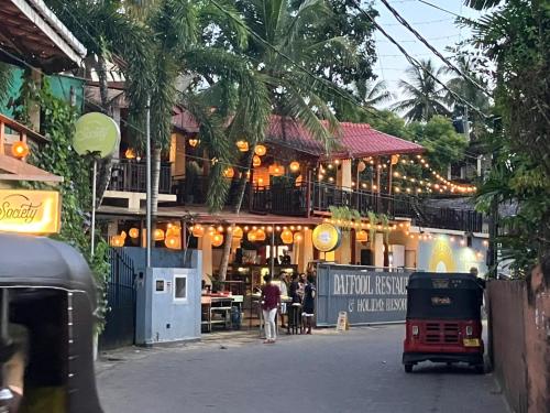 a building with people walking in front of it at Daffodil Restaurant & Holiday Resort in Unawatuna