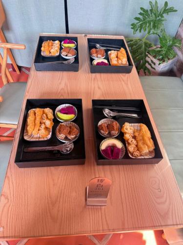 a table with three trays of food on it at 金門 日玥居 古厝民宿 Sunmoon19 B&B in Jinning