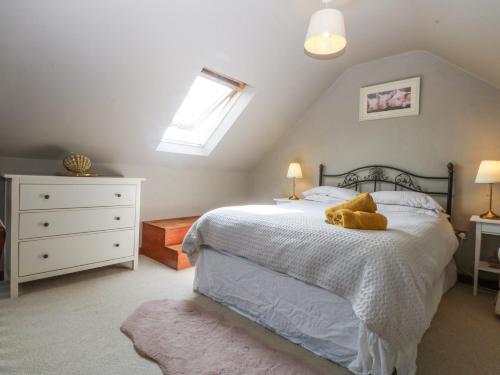 a bedroom with a bed with a teddy bear on it at Cegin Foch in Chwilog