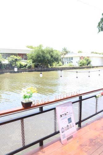 a sign on a railing next to a body of water at Grace Riverfront in Lat Krabang