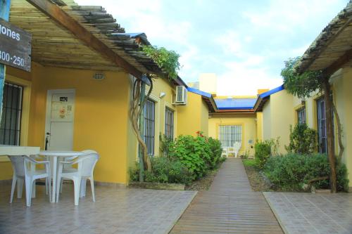 a table and chairs sitting outside of a yellow building at El Sueño de Pedro - Pileta Climatizada in Colón