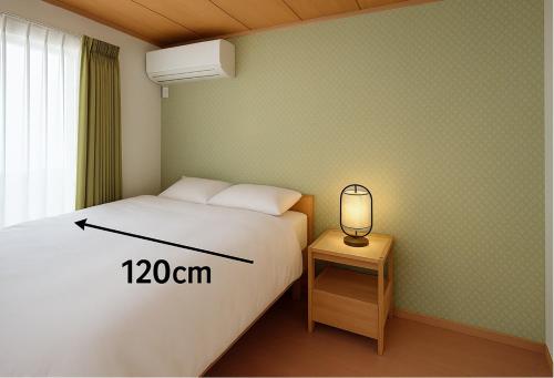 a bedroom with a bed and a lamp on a table at とまりーとStay 立会川 Tomareat Stay Tachiaigawa in Tokyo