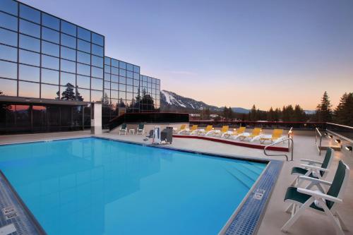einen Pool mit Stühlen und ein Gebäude in der Unterkunft Harveys Lake Tahoe Hotel & Casino in Stateline