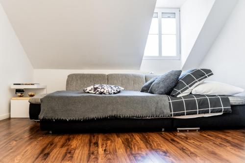 a bed in a room with a wooden floor at Celje Center Apartment in Celje