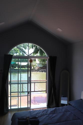 a bedroom with a window with a view of the water at Grace Riverfront in Lat Krabang