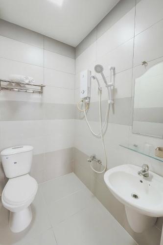 a white bathroom with a toilet and a sink at TK Diamond Hotel - Saigon Center in Ho Chi Minh City