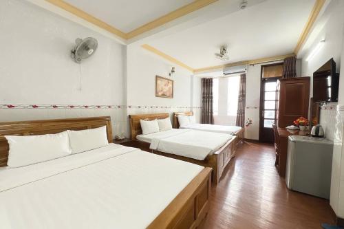 a hotel room with two beds and a television at TK Diamond Hotel - Saigon Center in Ho Chi Minh City