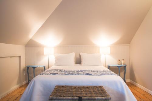 a bedroom with a large bed with two lamps at Auberge La Seigneurie in Matane