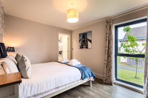 a bedroom with a bed and a window at Betony in Bamburgh