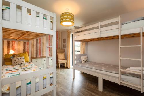 a bedroom with two bunk beds and a desk at Betony in Bamburgh