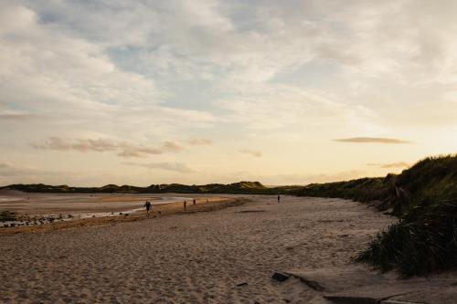 a group of people walking on the beach at Betony in Bamburgh