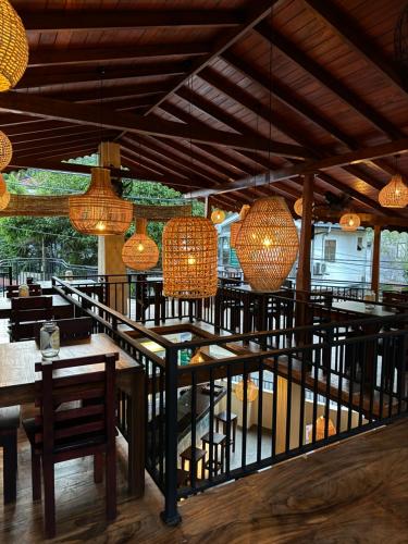 a restaurant with tables and chairs and chandeliers at Daffodil Restaurant & Holiday Resort in Unawatuna