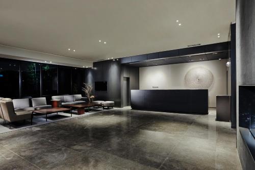 a lobby with chairs and tables and a large screen at Ramada by Wyndham Gunsan in Gunsan