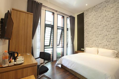 a hotel room with a bed and a desk and window at Dago Teuku Angkasa 14 in Bandung