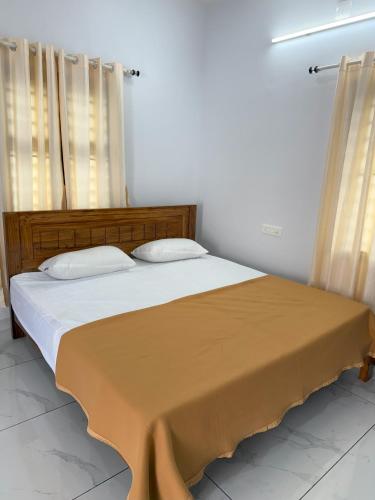 a bedroom with a large bed with two pillows at Joseph's Residency Homestay in Podanūr