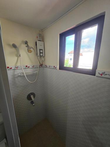 a bathroom with a shower and a window at Beautiful four bedroom home in Talisay