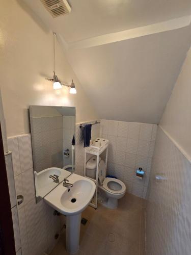 a bathroom with a sink and a toilet at Beautiful four bedroom home in Talisay