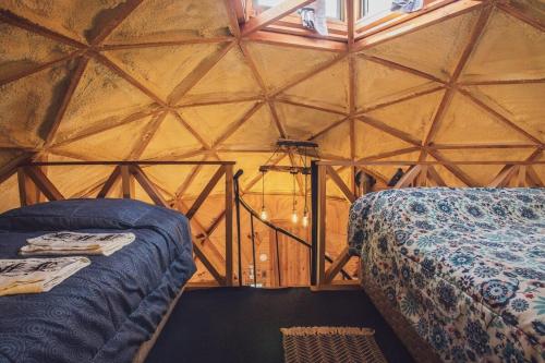 a room with two beds in a yurt at Domo Osiris a 10 minutos de termas Vergara in Coñaripe