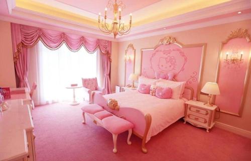 a pink bedroom with a large bed and a chandelier at Yin Run Jin Jiang Castle Hotel in Huzhou