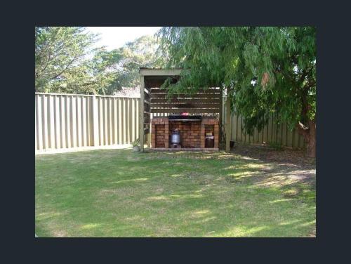 a backyard with a wooden fence and a fireplace at Home on the Bay on Esplanade and Buller St Kingscote-3 people in 2 nights get the 3rd night free in Parndana