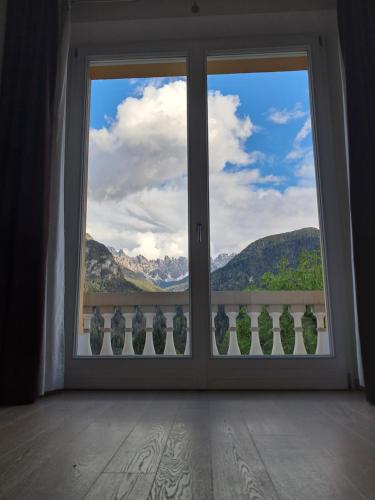 a room with a window looking out at the mountains at Villa Emilia nelle Dolomiti in Domegge di Cadore