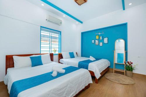 a bedroom with two beds and a blue wall at Villa Hồ Bơi Bida Karaoke Sân Nướng BBQ in Vung Tau
