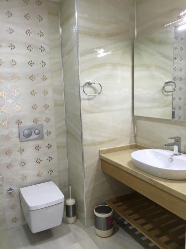 a bathroom with a sink and a toilet and a mirror at Clementin Suits Sigacık in Siğacık