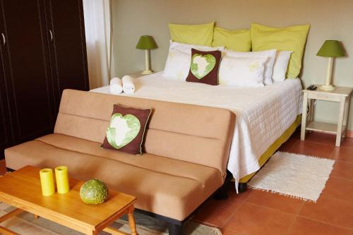 una camera con un letto, un divano e un tavolo di The Fever Tree Guest House a Hluhluwe