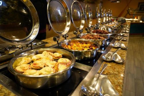a buffet line with many dishes of food in bowls at L'Heritage Riverside Hoi An in Hoi An