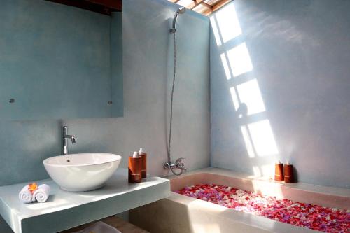 a bathroom with a sink and a bath tub with a window at Villa Tegal Tis Ubud in Payangan