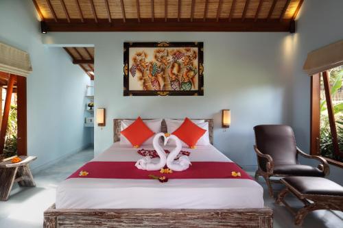 a bedroom with a bed with two swans on it at Villa Tegal Tis Ubud in Payangan