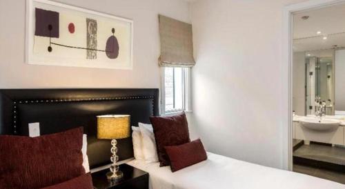 a bedroom with a bed and a bathroom with a sink at Oaks Queenstown Club Suites in Queenstown