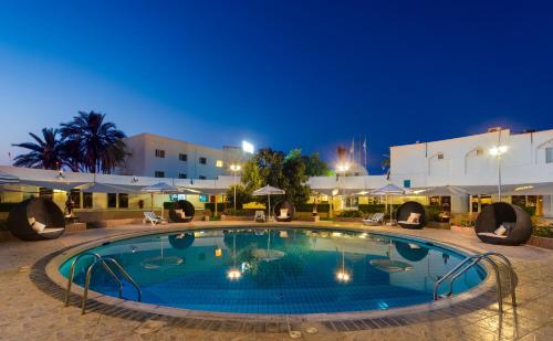 a large swimming pool in a resort at night at Al Wadi Hotel in Sohar