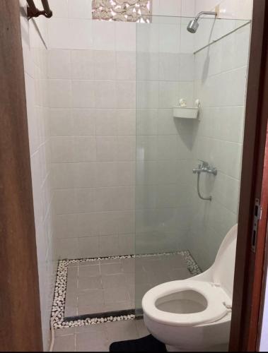 a bathroom with a toilet and a glass shower at RBE Hotel Kuta 2- 5 Min to Airport&Beach by Micky Studio in Ngurah Rai International Airport