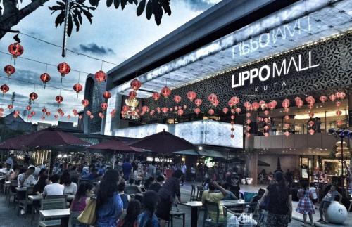 a group of people sitting at tables outside of a building at RBE Hotel Kuta 2- 5 Min to Airport&Beach by Micky Studio in Ngurah Rai International Airport