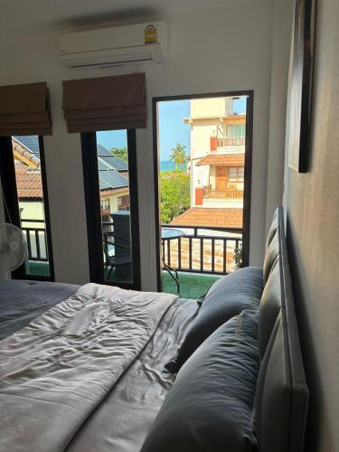 a bedroom with a bed with a view of a balcony at Lamai Beachroad Apartment in Lamai