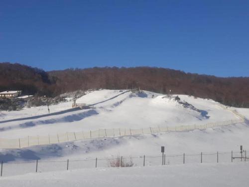 a snow covered hill with a fence on top of it at Villa in Tagliacozzo with Pool and Nature in Tagliacozzo