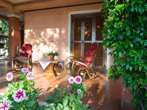 a patio with two chairs and a table and flowers at Villa in Tagliacozzo with Pool and Nature in Tagliacozzo