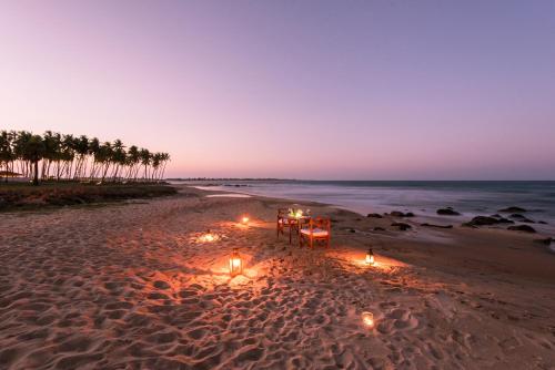 a table and lights on the beach at night at Jetwing Kottukal Beach House in Arugam Bay