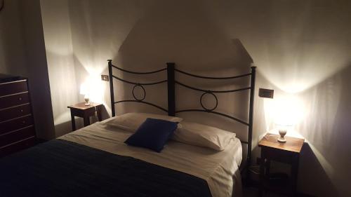 una camera da letto con un letto con un cuscino blu e due lampade di Agriturismo Pomonte a Orvieto