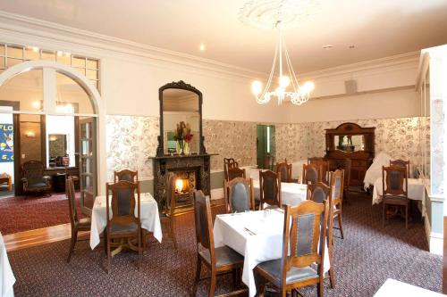 a dining room with tables and chairs and a fireplace at Yarra Valley Grand in Yarra Glen