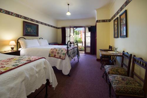a hotel room with two beds and a table and chairs at Motel Maldon in Maldon