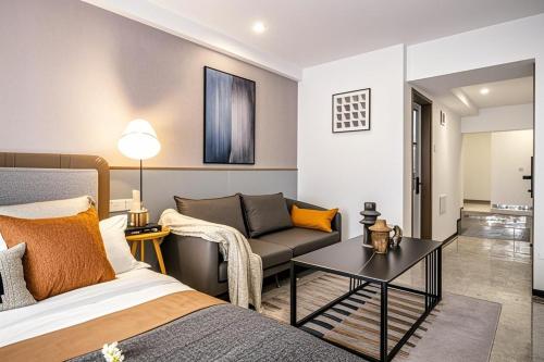 a bedroom with a bed and a couch and a table at Yoo Man Joo City View Hotel - Guangzhou Canton Tower Pazhou Convention and Exhibition Center Store - Canton Fair Exclusive in Guangzhou