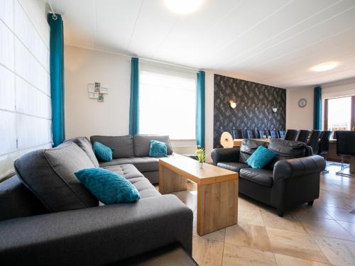 a living room with two couches and a table at Villa East Canton with Sauna in Nieder-Emmels