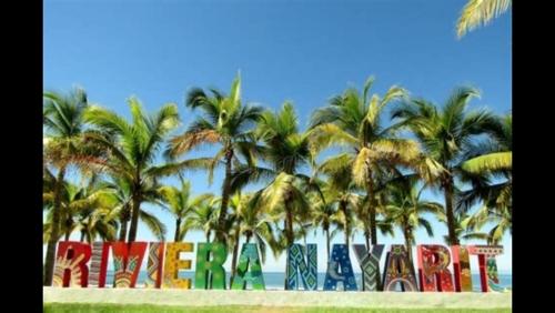 a group of palm trees in front of a sign at Suite Privada frente a Vidanta Queen in Nuevo Vallarta