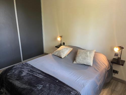 Un dormitorio con una cama con dos almohadas encima. en Villa de Koh Samui, en Colomiers