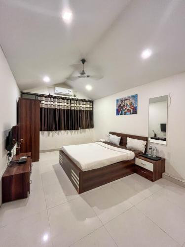 a bedroom with a large bed and a mirror at Swarg Resort in Pune