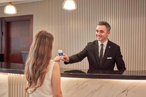 a man in a suit and tie holding a cell phone at Konak Hotel Taksim in Istanbul