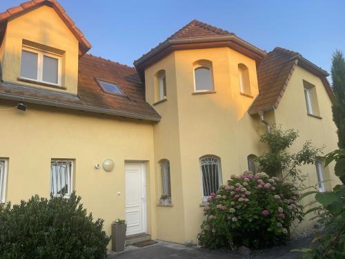 a yellow house with a white door at Villa "La Tourelle" avec piscine privée in Haguenau